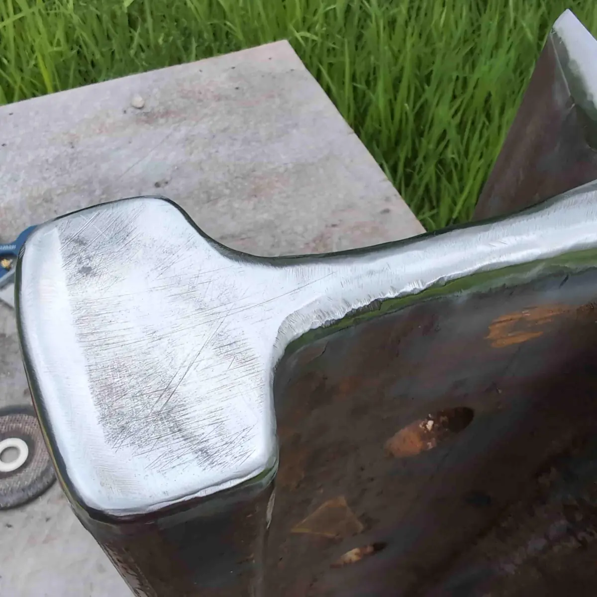 Close up showing many surface scratches on the striking face of a rail anvil.