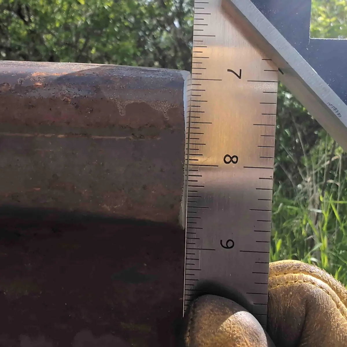 A close up showing the face of the rail anvil with a straight edge against it. You can no longer see light thru the gap.